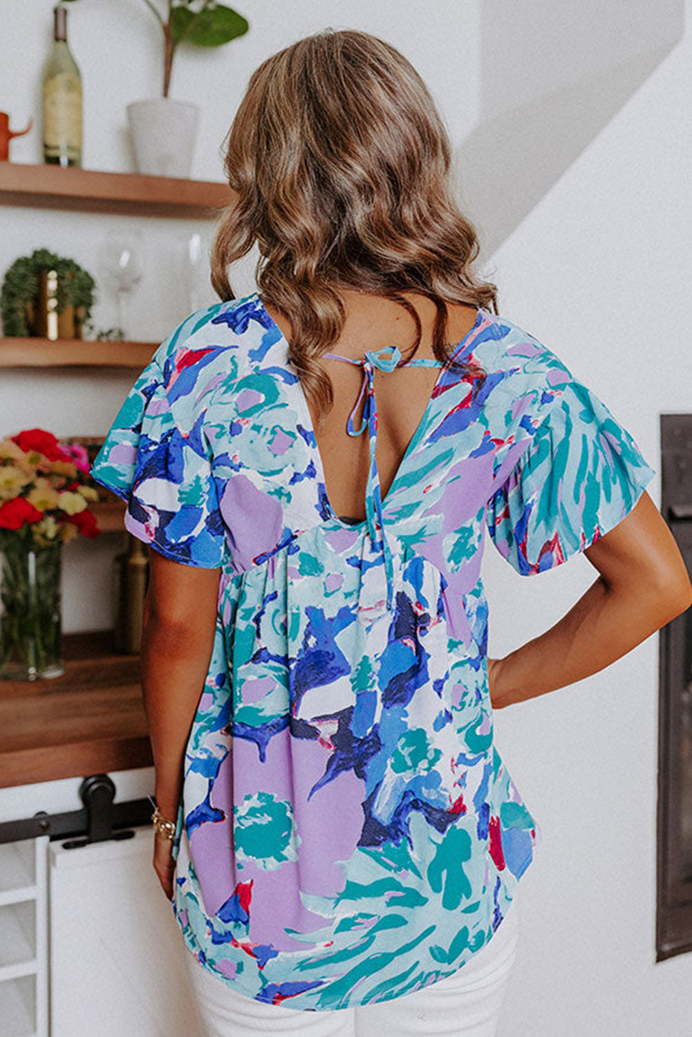 Hemelsblauwe blouse met abstracte print en V-hals met fluttermouwen