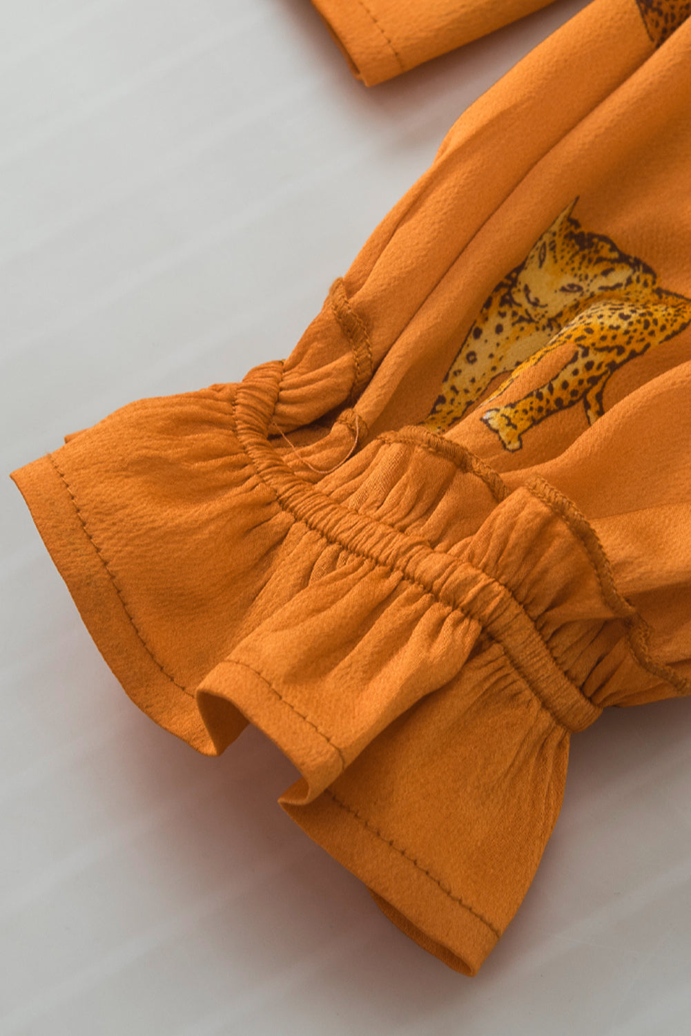 Oranje blouse met cheetah-print en gegolfde mouwen