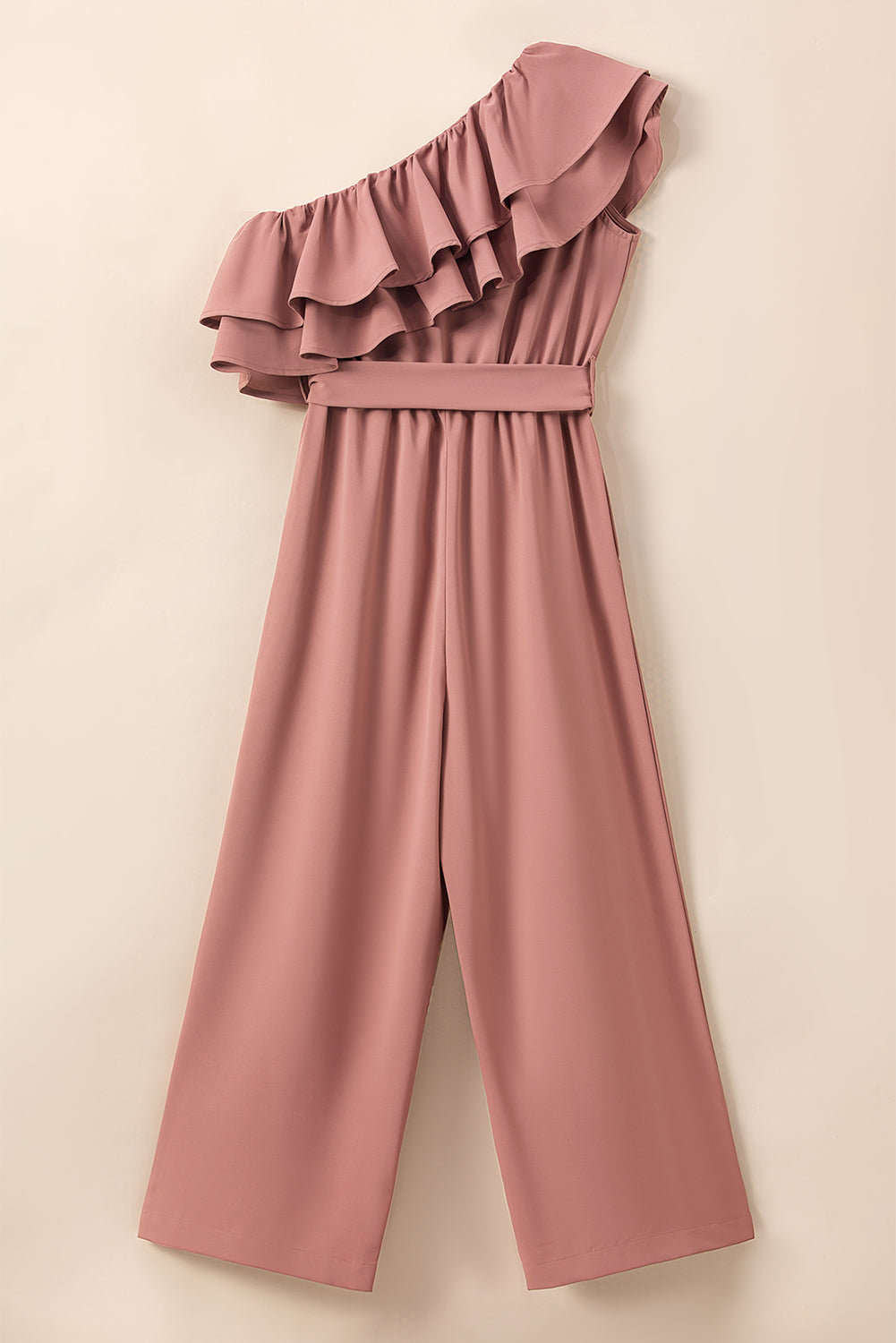 Stoffig roze jumpsuit met één schouder en ruches en riem