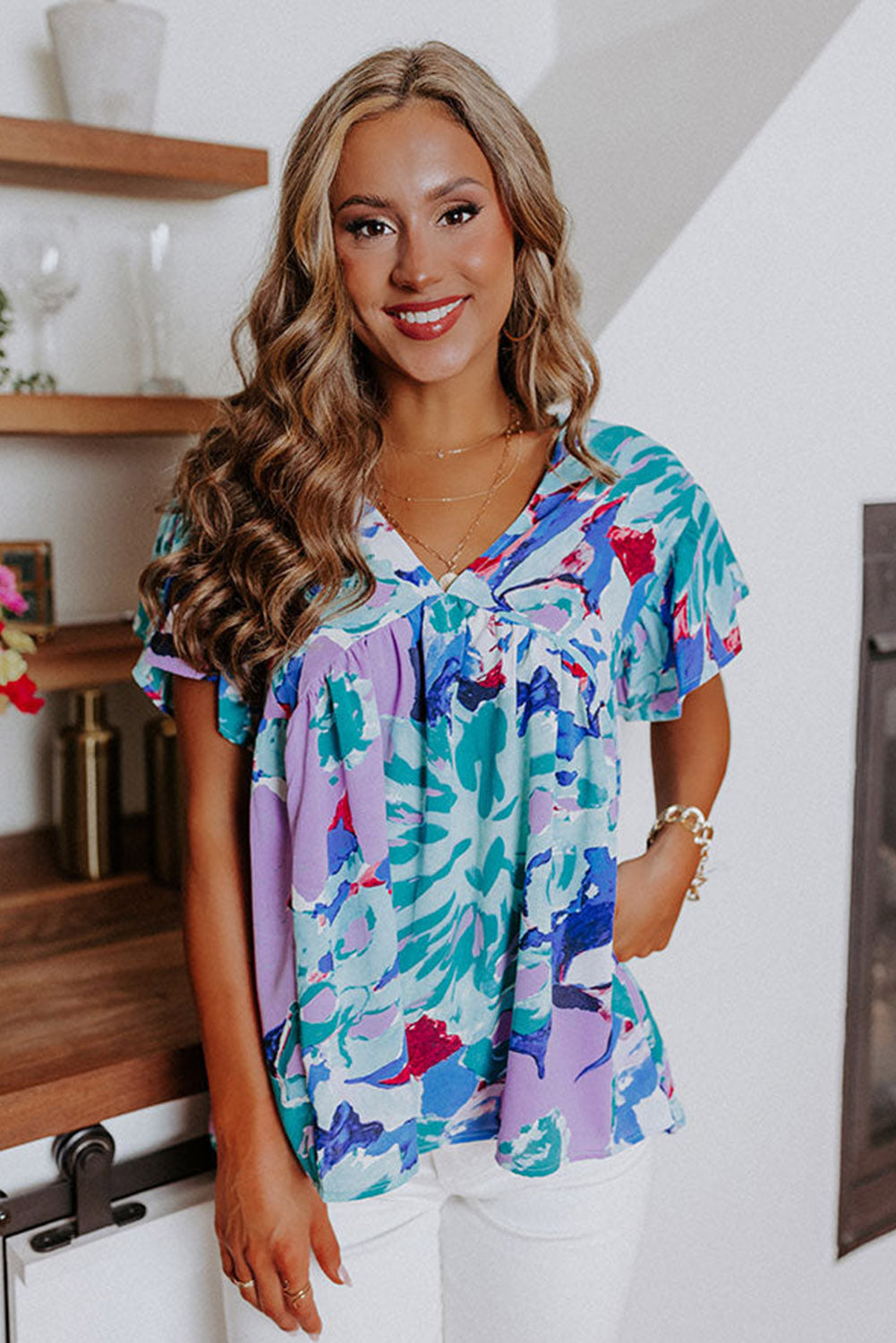 Hemelsblauwe blouse met abstracte print en V-hals met fluttermouwen