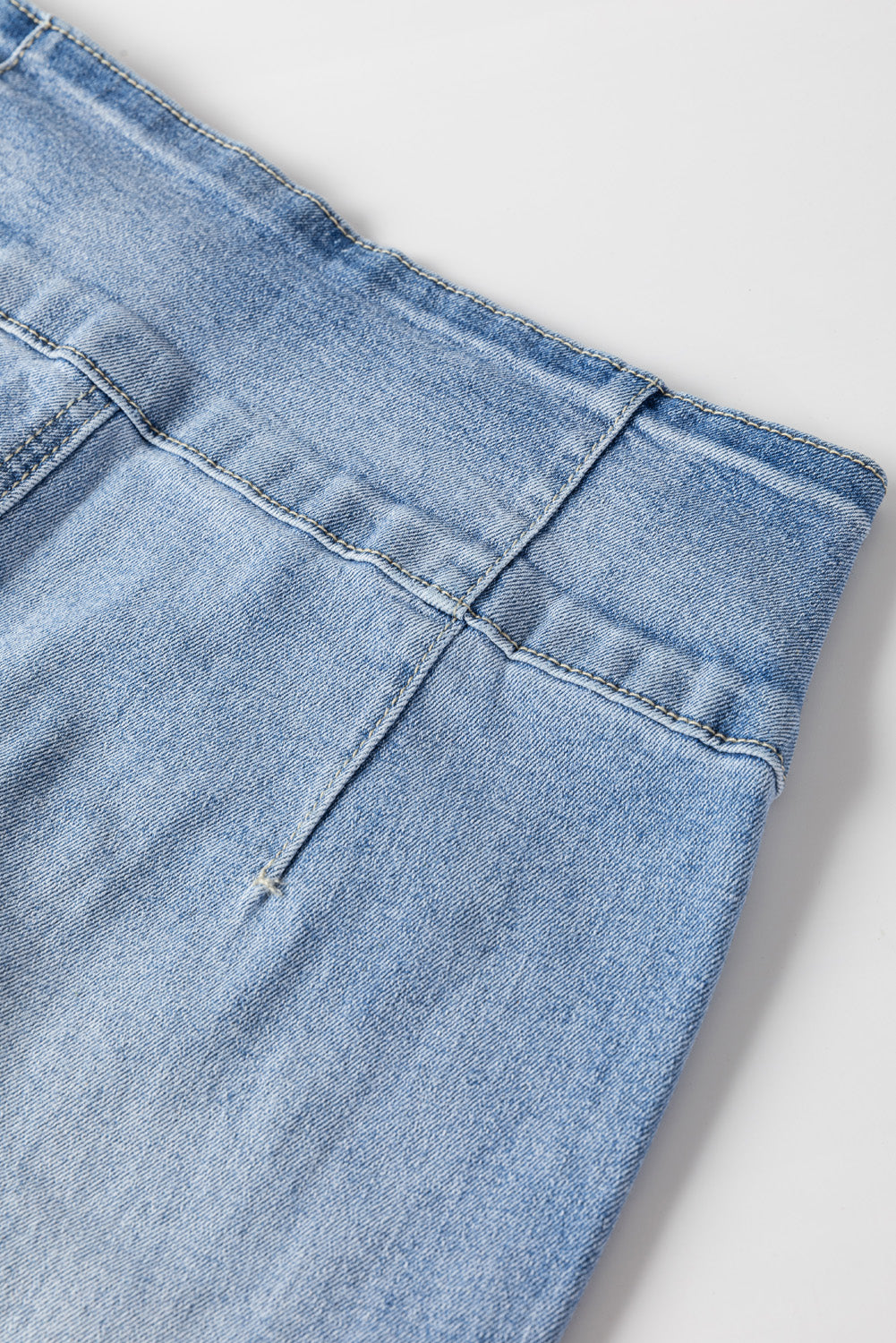 Lichtblauwe jeans met knoop en zichtbare naad en opgestikte zak