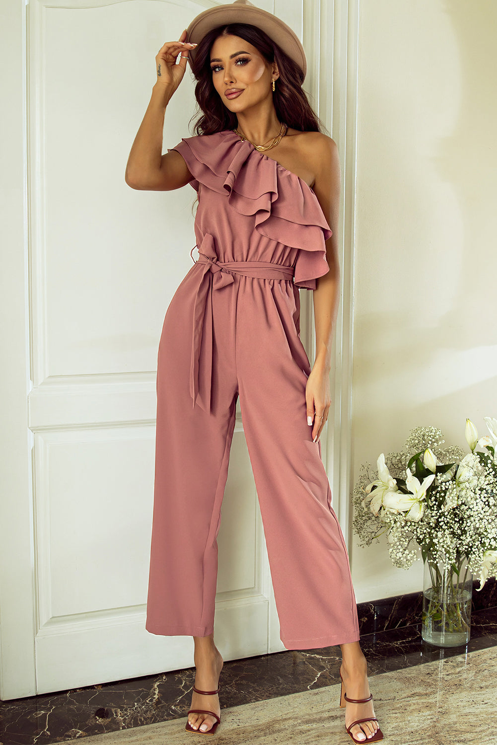 Stoffig roze jumpsuit met één schouder en ruches en riem