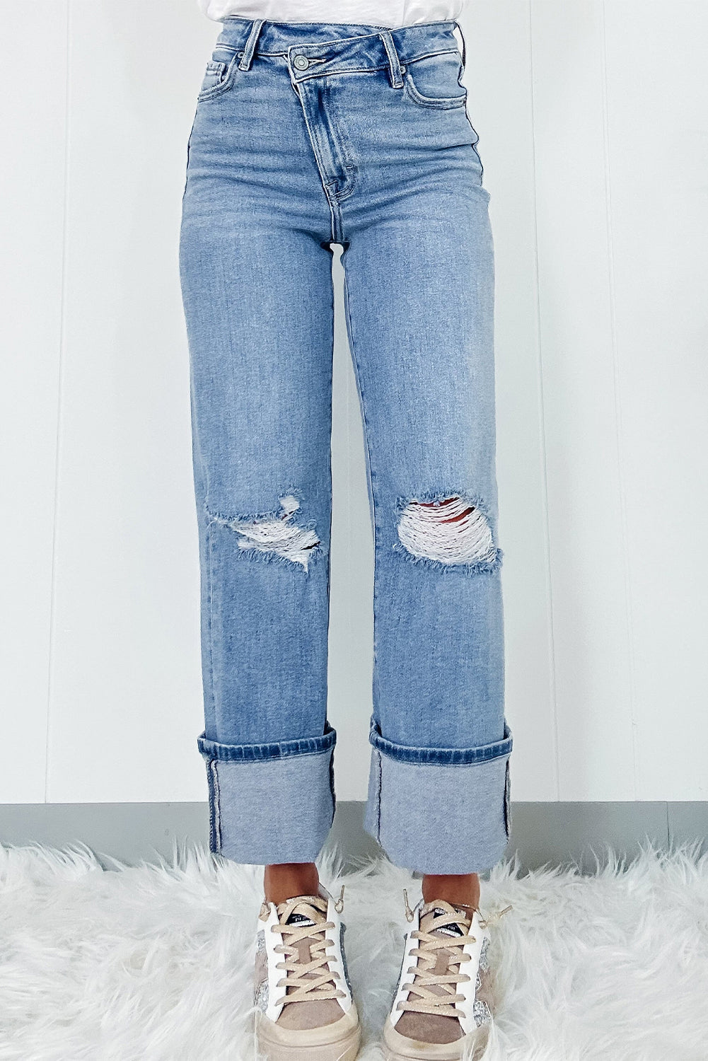 Schemerblauwe asymmetrische gescheurde jeans met knoopsluiting en hoge taille