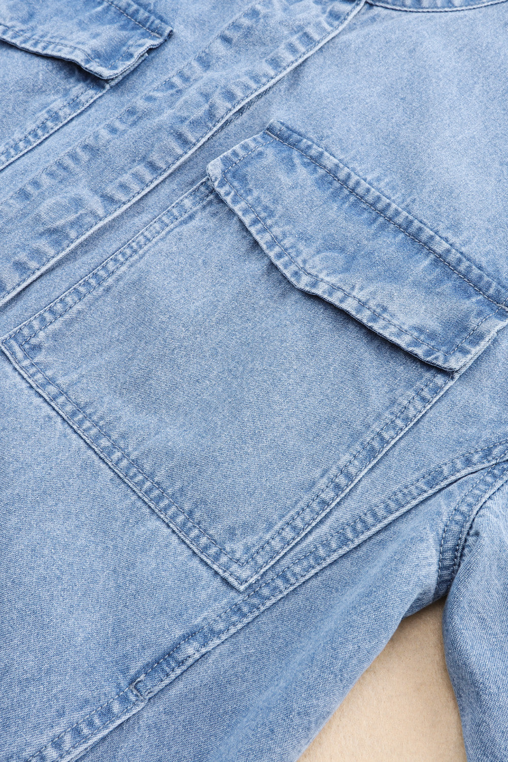 Hemelsblauw denim jack met oprolbare tabmouw en knoopsluiting met zak