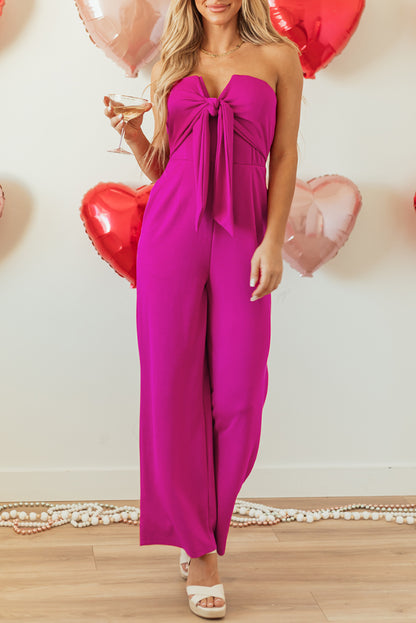 Felroze strapless jumpsuit met strik en wijde pijpen