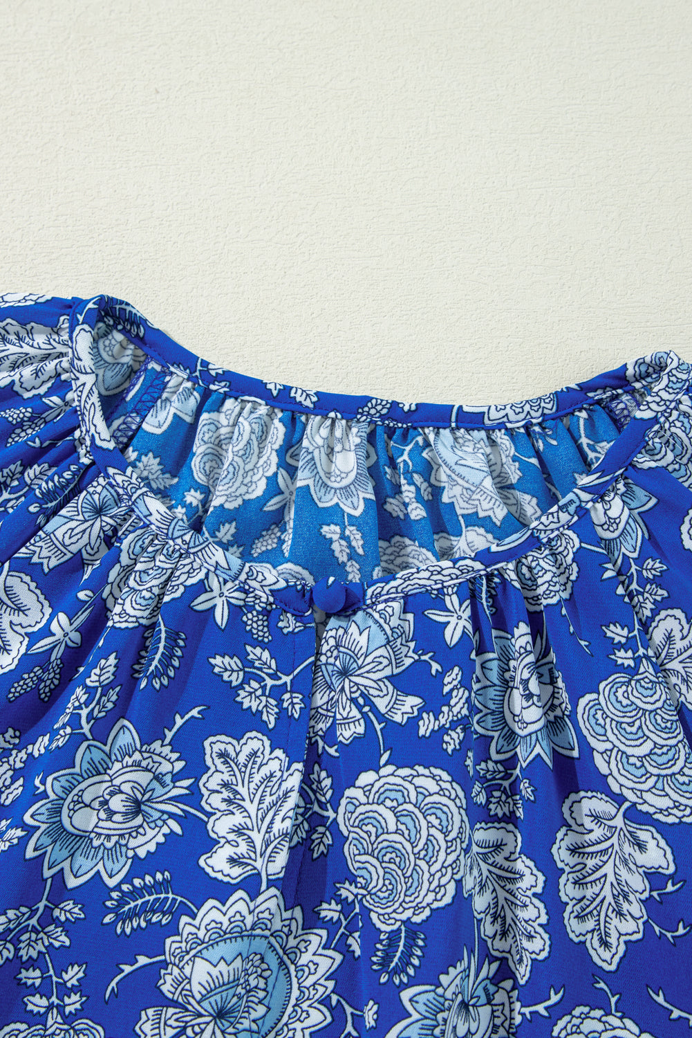 Blauwe blouse met ingekerfde V-hals en lange mouwen met bloemen