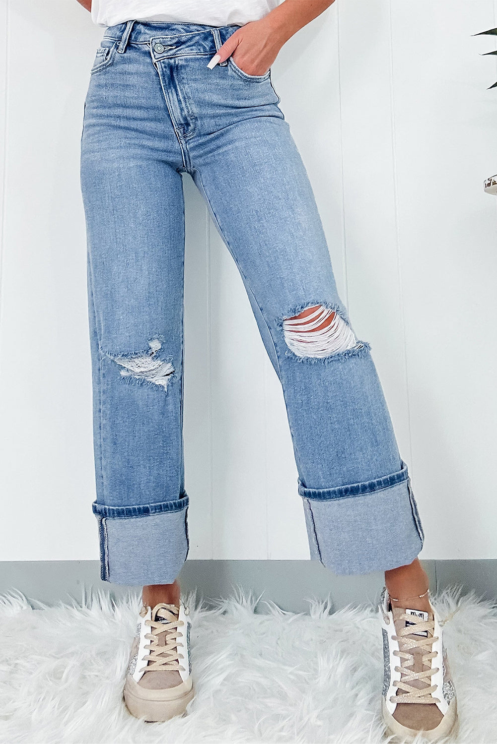 Schemerblauwe asymmetrische gescheurde jeans met knoopsluiting en hoge taille