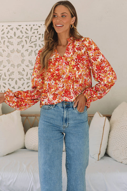 Grapefruit oranje bloemenblouse met ruches en splitnek en bubbelmouwen