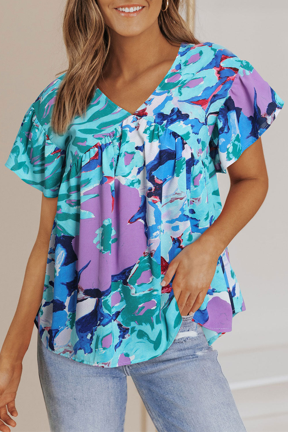 Hemelsblauwe blouse met abstracte print en V-hals met fluttermouwen